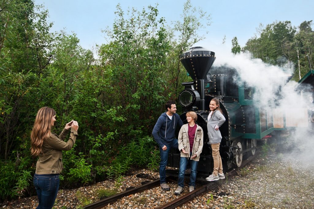 Family taking a picture in front of a train in Alaska