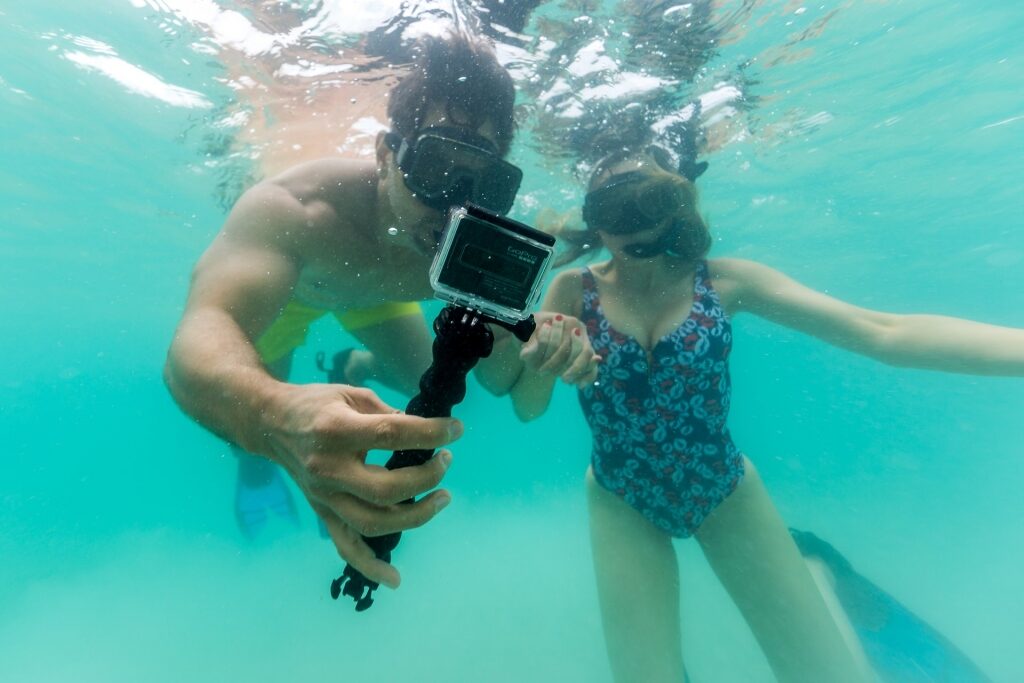 Couple snorkeling with GoPro camera
