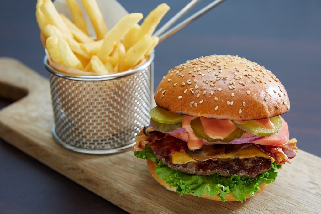 Delicious cheeseburger and fries on a wooden platter