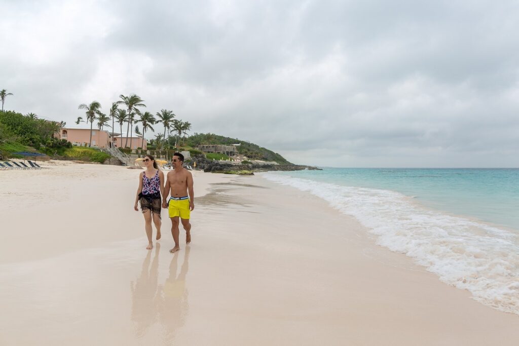 Couple walking along Elbow Beach