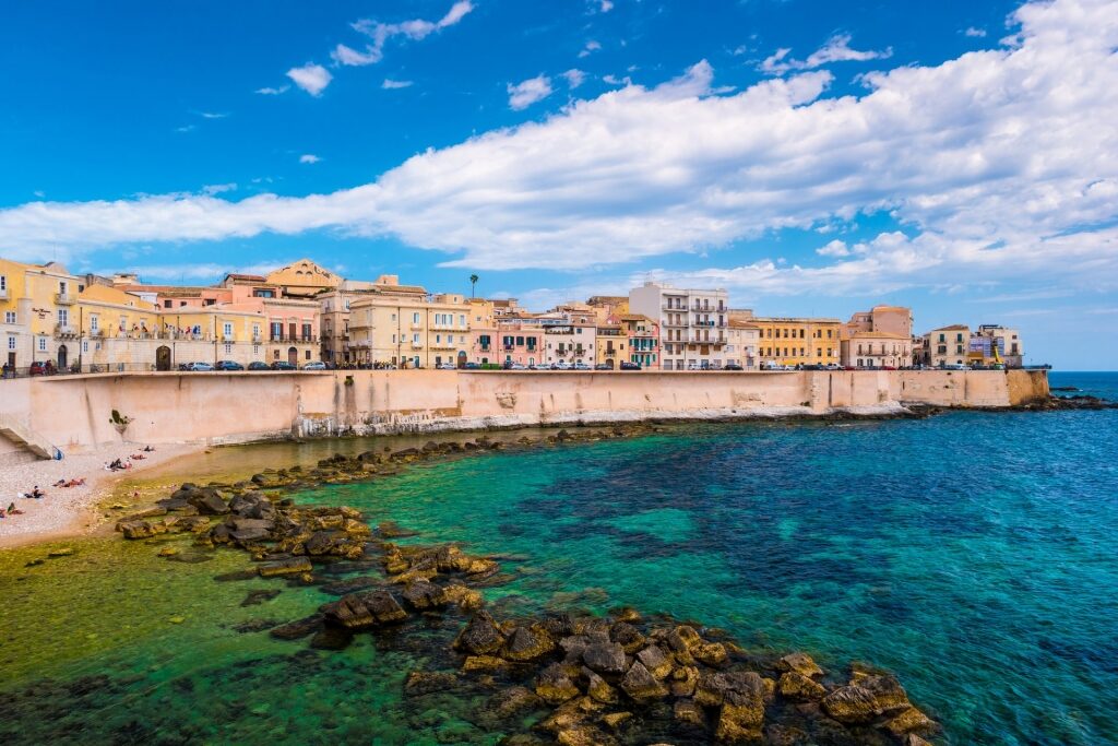 Island of Ortigia with buildings lined up by the water