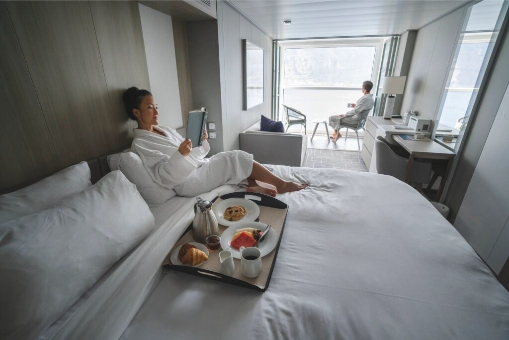 Couple relaxing inside Infinite Veranda stateroom aboard Celebrity Cruises