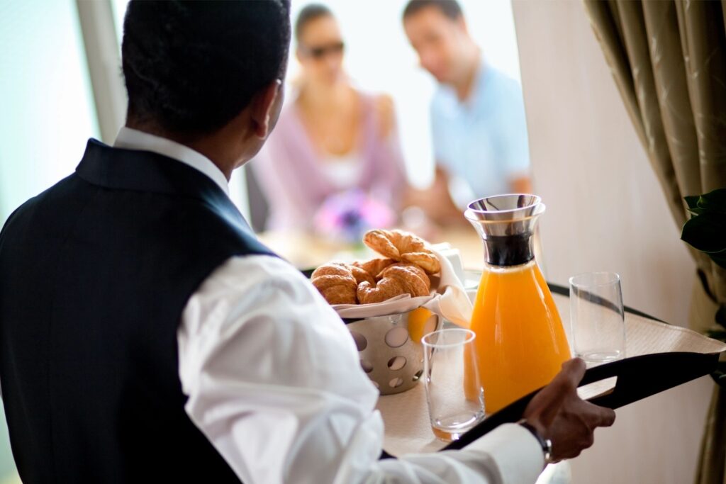 Stateroom attendant holding breakfast tray