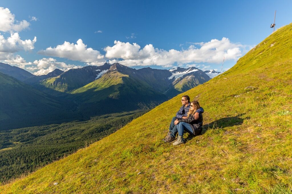 Couple sitting on a mountain slope in Alaska