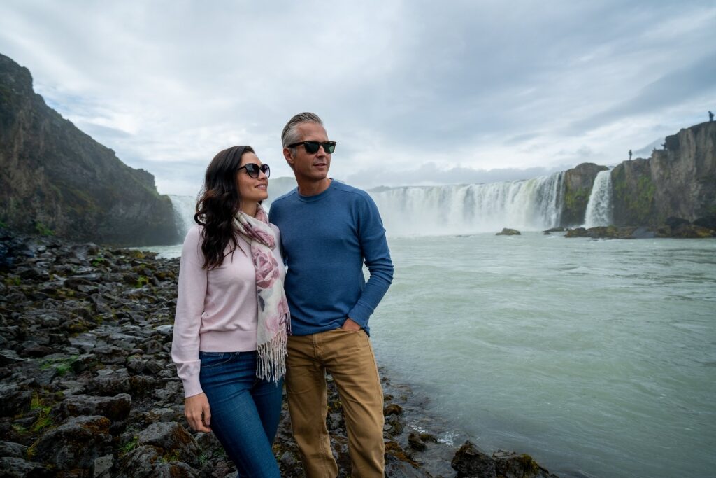 Couple standing near the Godafoss Waterfall, Iceland