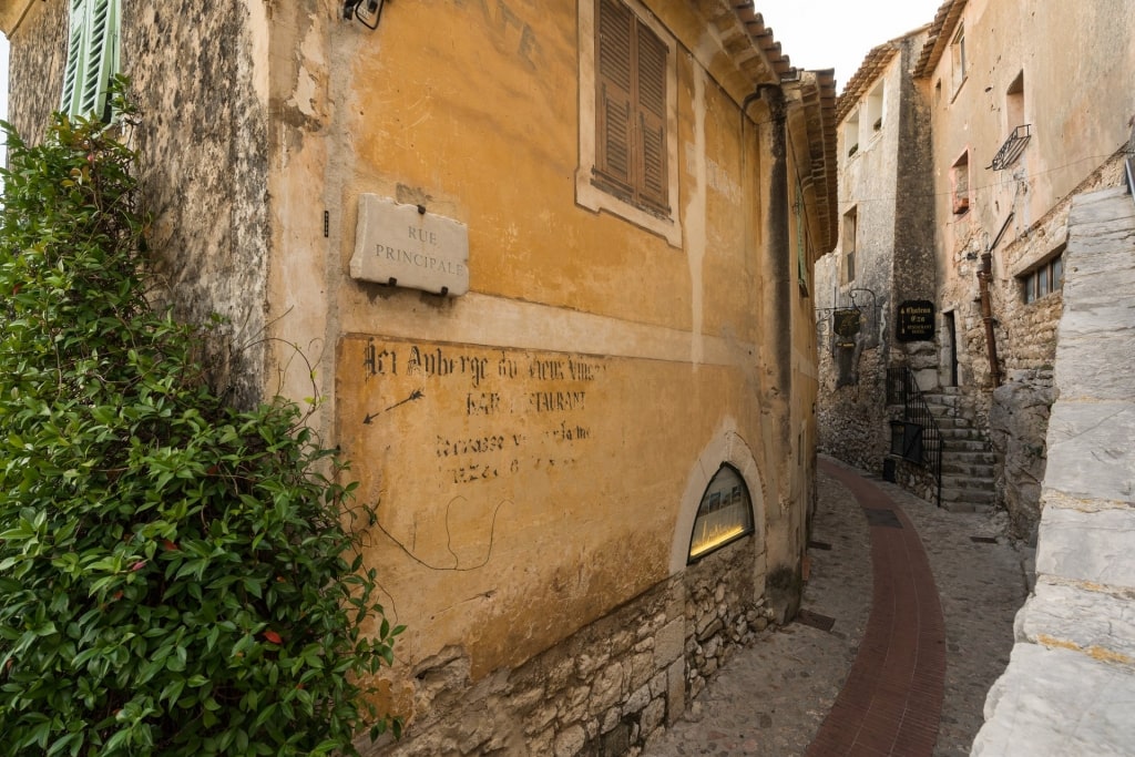  Antiguos edificios de piedra en la calle adoquinada de Eze