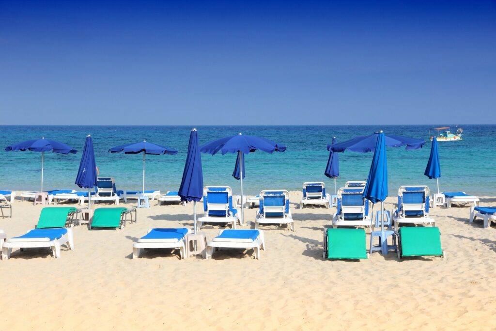 Blue beach chairs lined up in Makronissos Beach