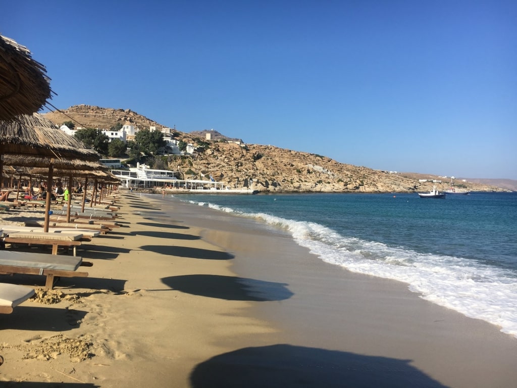 Kalo Livadi Beach with soft waves and beach lounge chairs