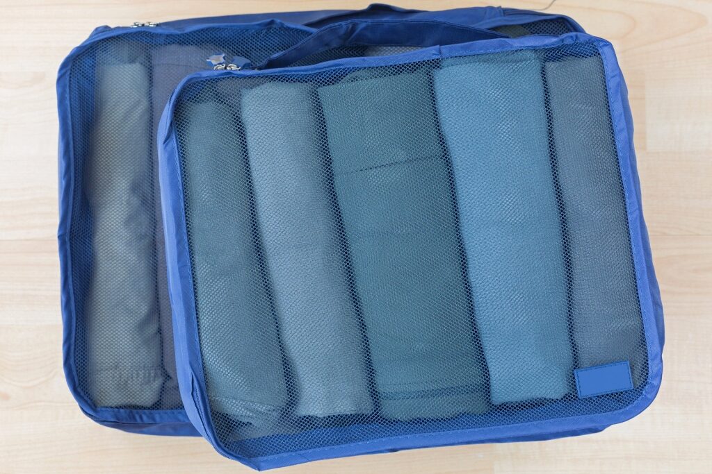 Blue packing cubes with rolled clothes