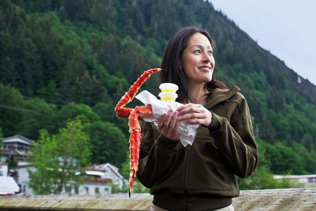 Woman holding steamed King Crab with butter