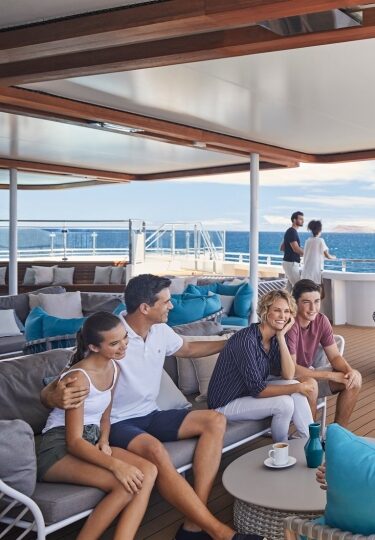 Cruises for large families - family hanging out on a cruise deck