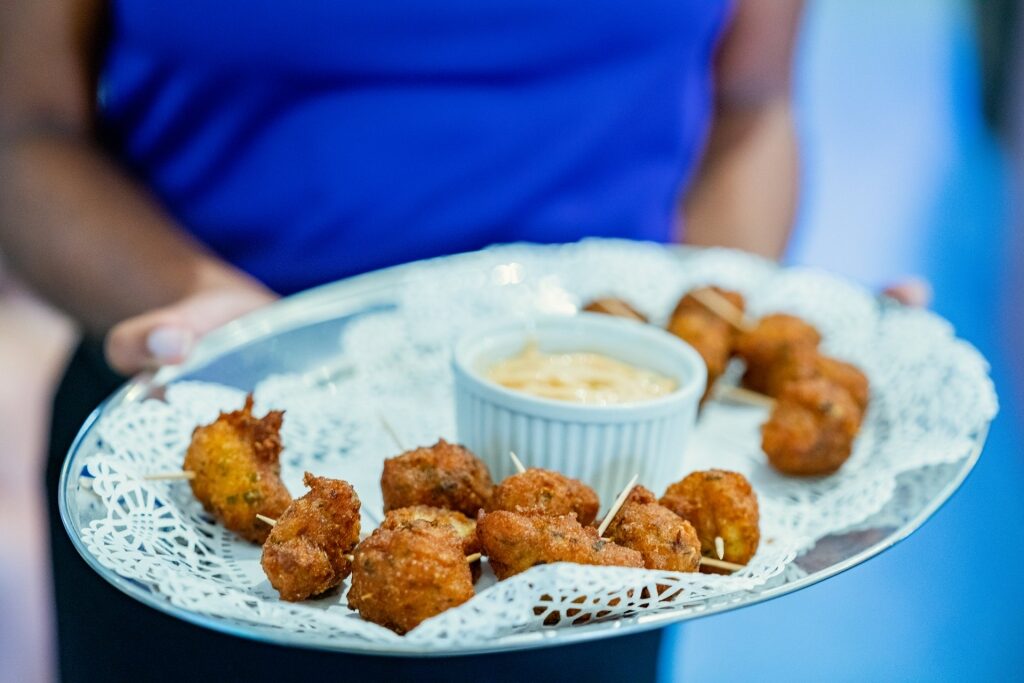 Woman holding a plate of conch fritters