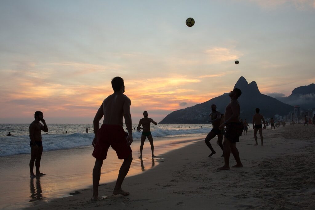 People playing soccer at the beach
