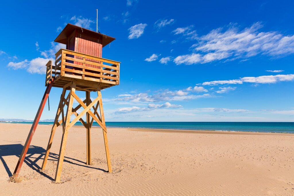 Brown sands of Canet d’en Berenguer Beach with outpost