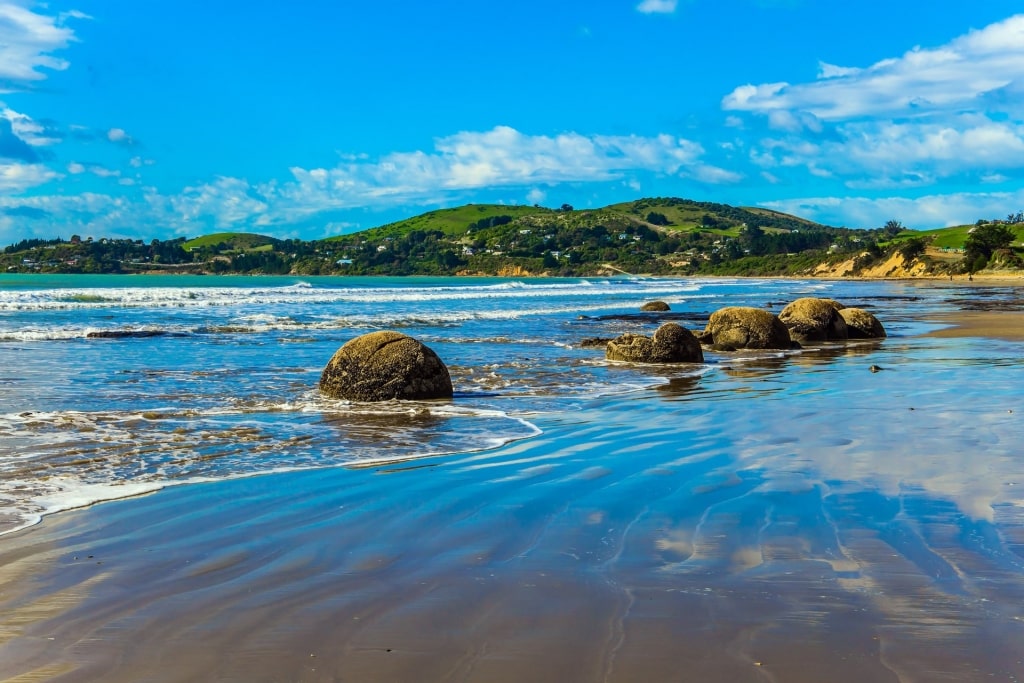 Clear waters of Koekohe Beach with massive rocks