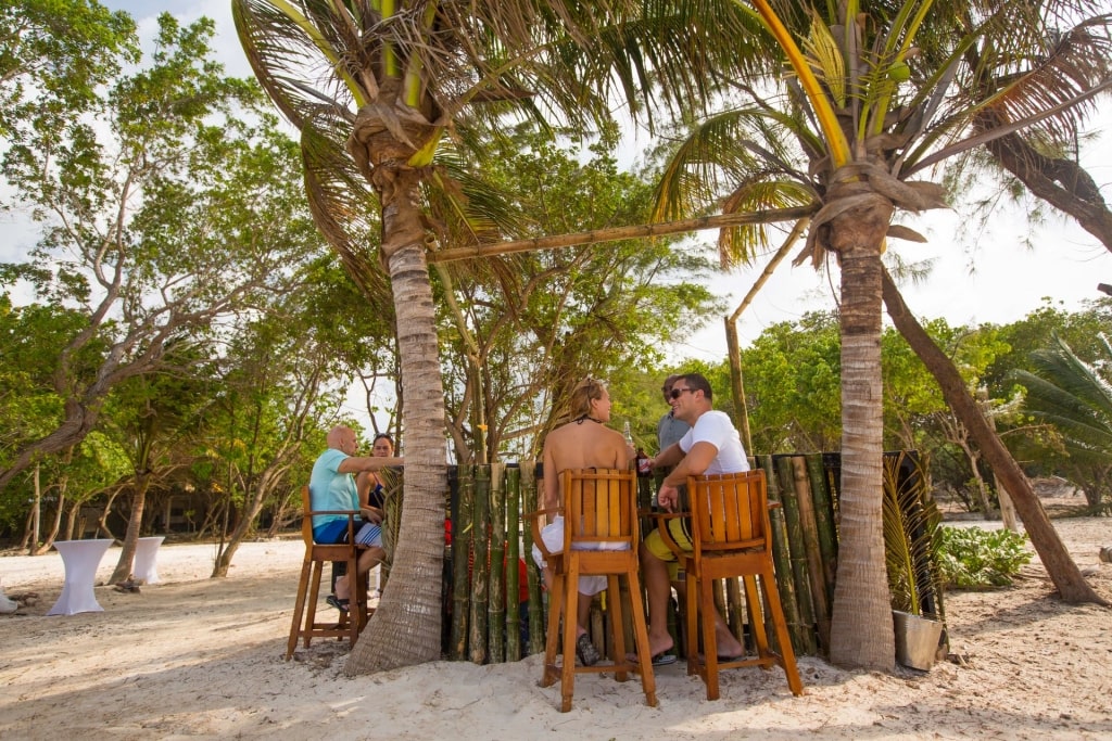 People hanging out over drinks at a beach in Jamaica