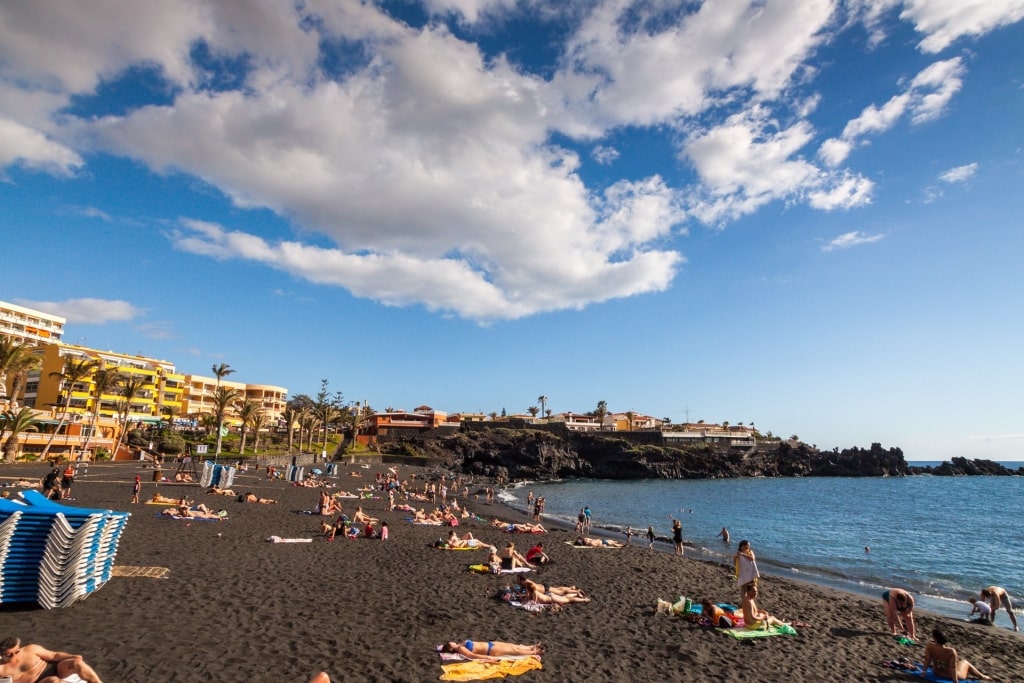 People relaxing on the black sands of Playa de La Arena, West Coast 