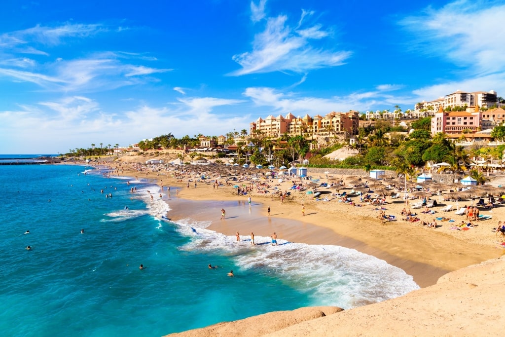 People lounging on the golden sands of Playa del Duque