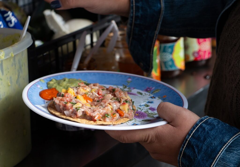 Man eating a plate of Ceviche tostadas