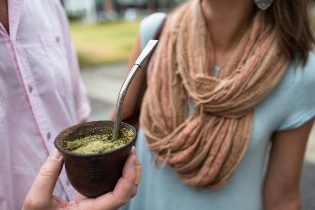 Man holding a small cup of mate