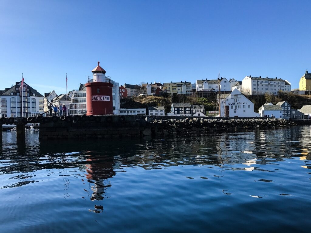 Old waterfront of Ålesund with iconic red lighthouse