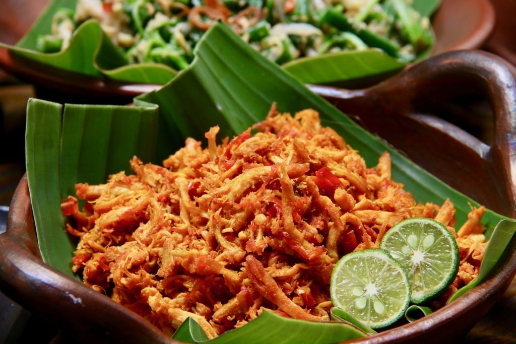 Flavorful plate of Ayam Pelalah on banana leaves