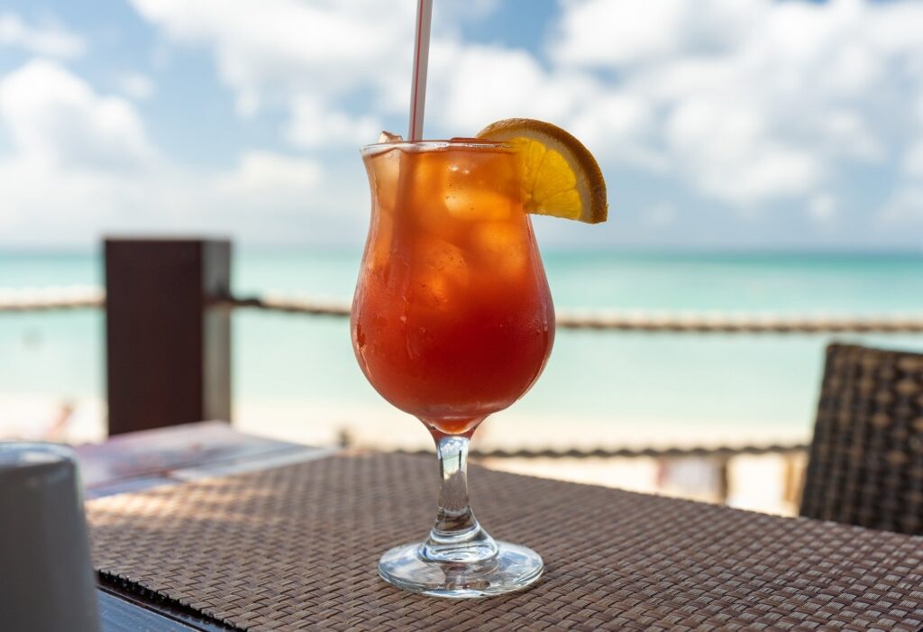Glass of Aruba Ariba at a beachside restaurant