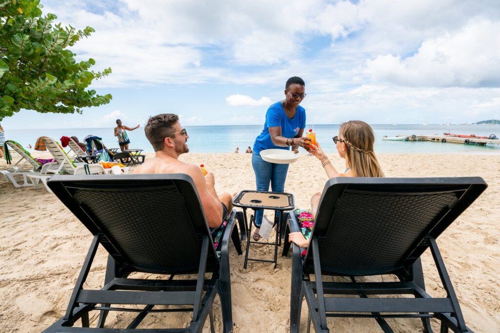 Couple drinking cocktails at a beach in Grenada