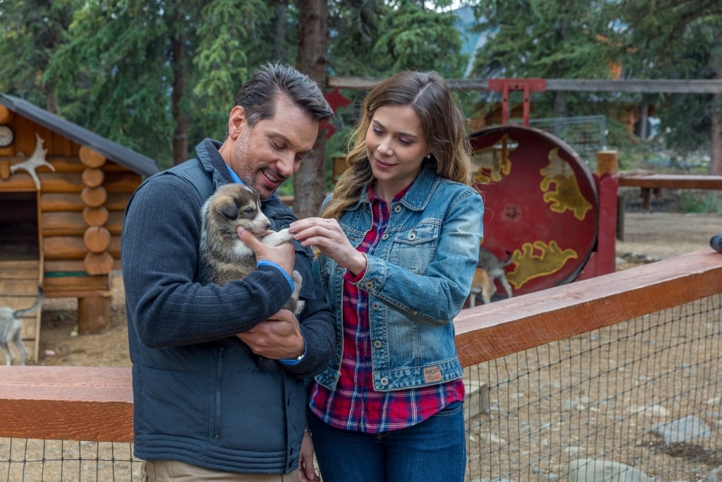 Couple snuggling with a puppy in Husky Homestead, Denali National Park