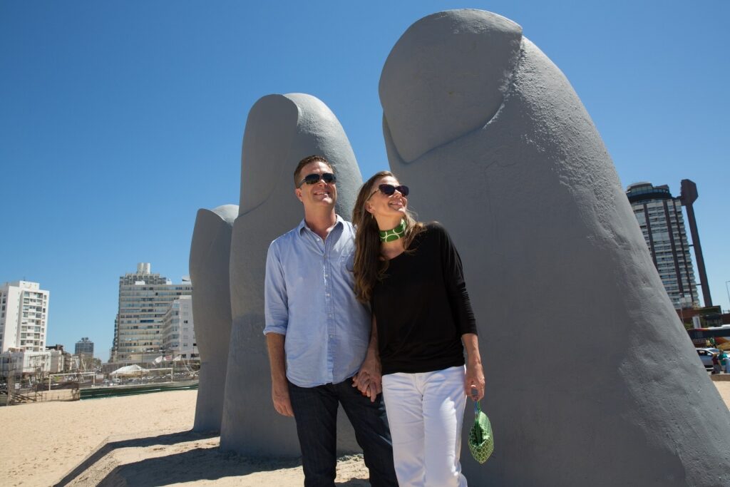 Couple beside the iconic Hand sculpture