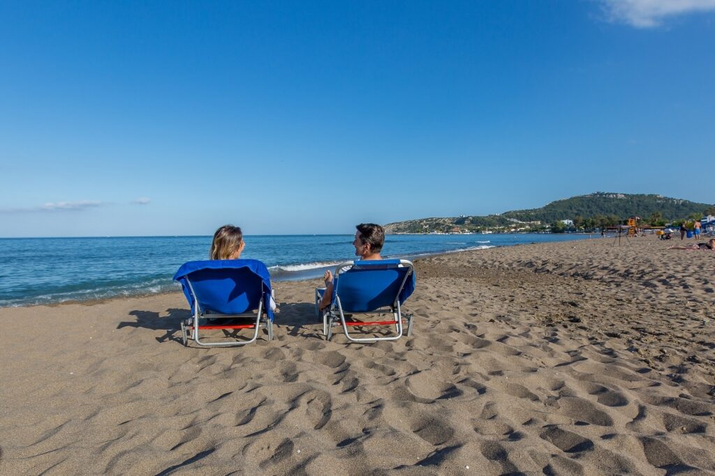 Couple lounging on Faliraki Beach in Rhodes, Greece