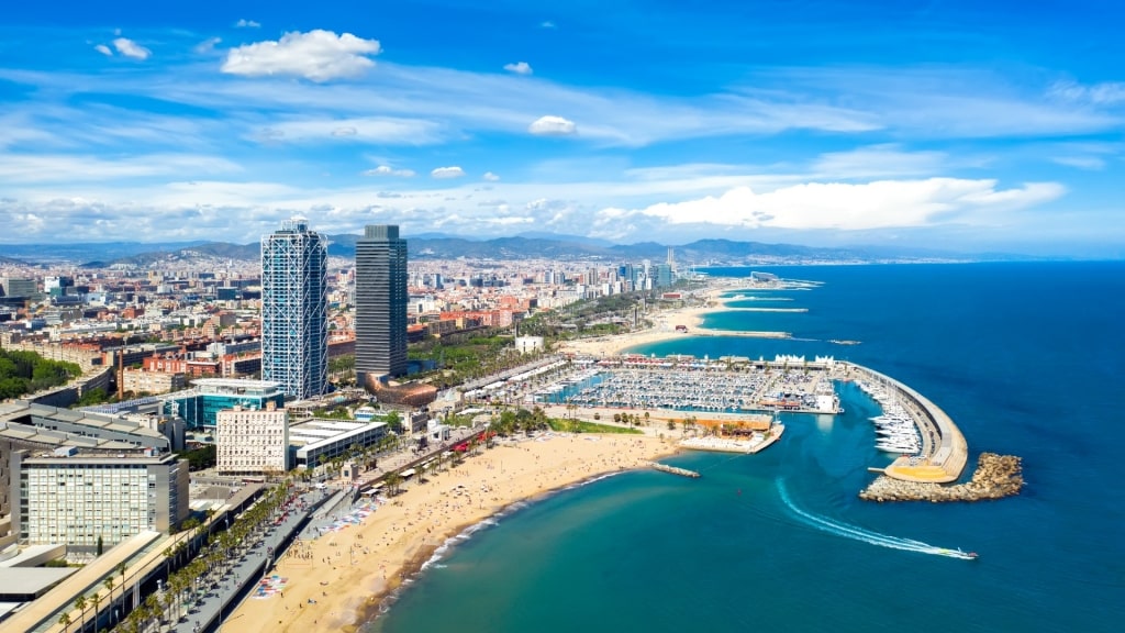 Shoreline of Somorrostro Beach with buildings towering over the sands