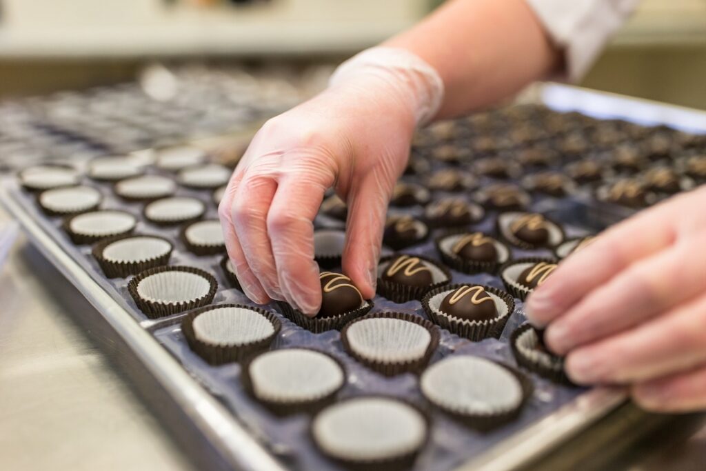 Person preparing chocolates at the Makana Boutique Chocolate Factory, Picton