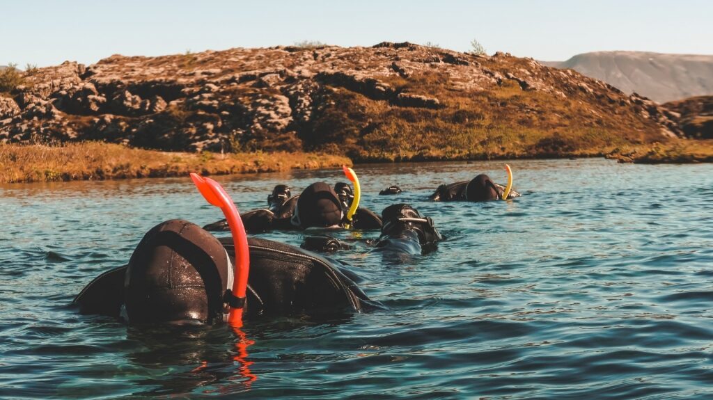 People snorkeling in Silfra Fissure, Iceland