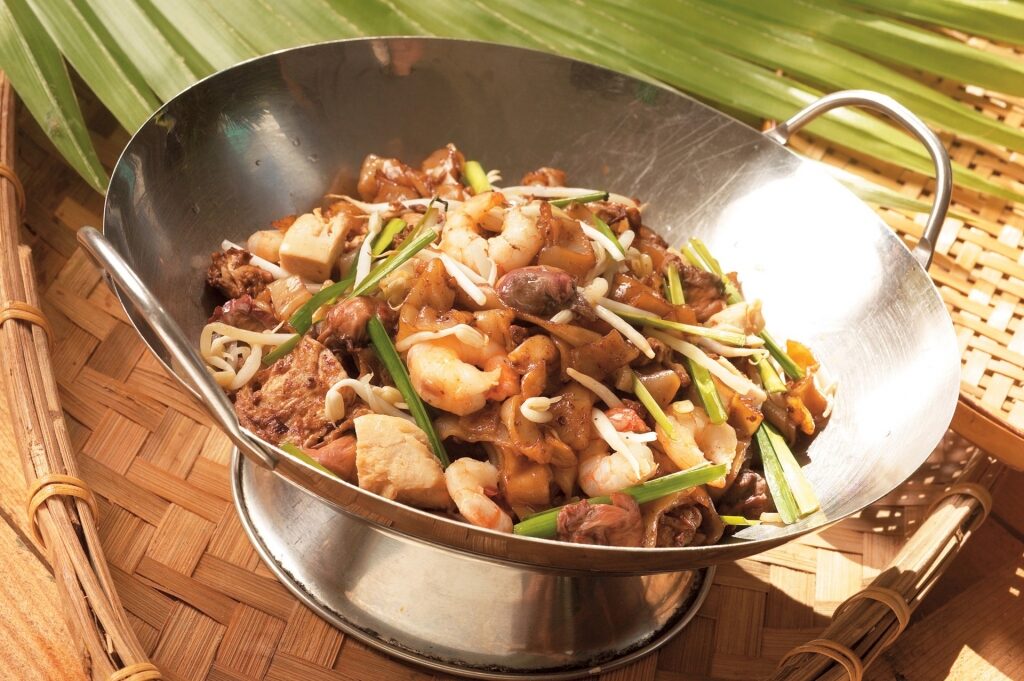 Char kway teow in a wok pan