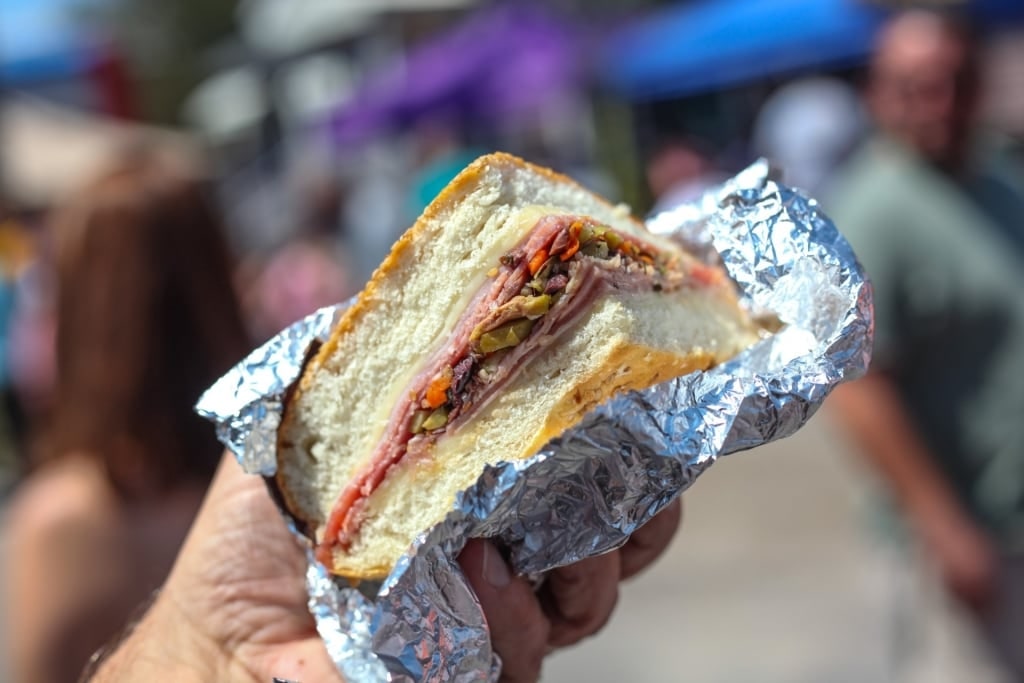 Man holding a Muffuletta sandwich