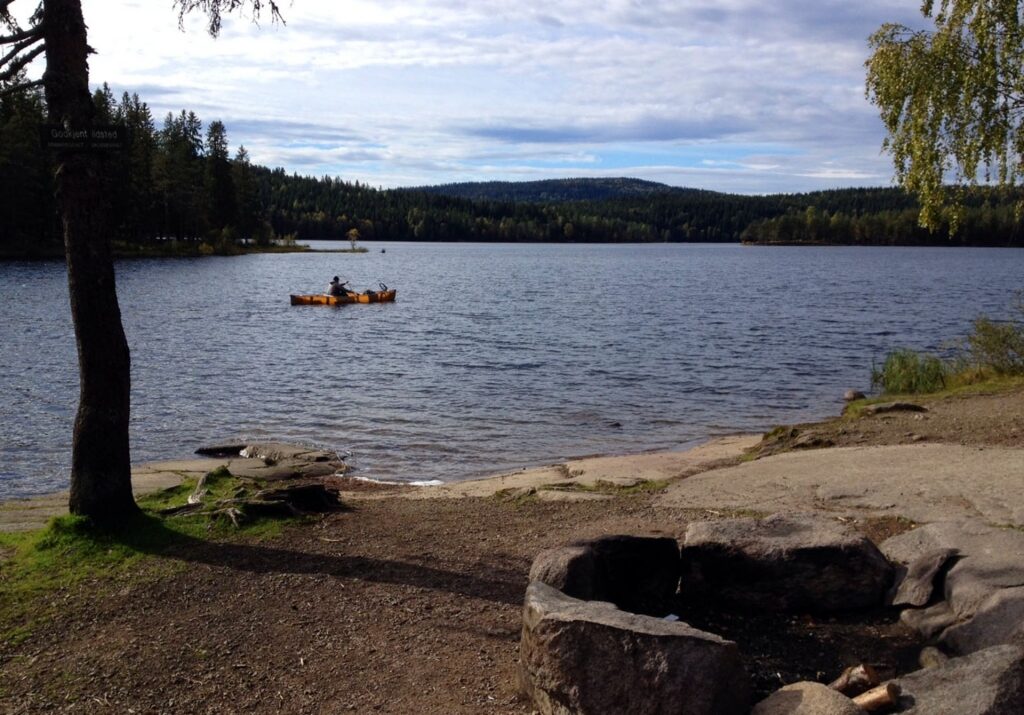 Person kayaking in the lake near Mellomkollen Mountain, Oslo