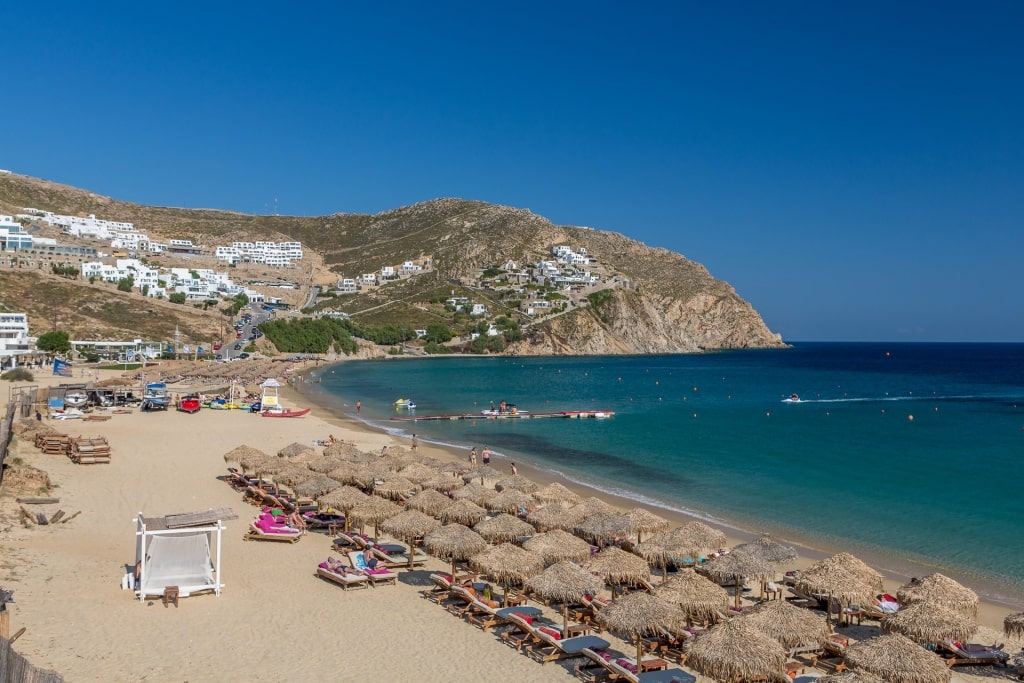 Beach umbrellas lined up on Elia Beach in Mykonos, Greece