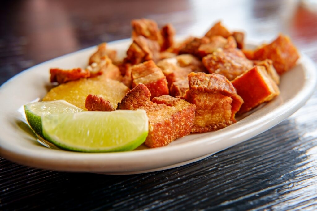 Plate of meaty chicharrón with lime