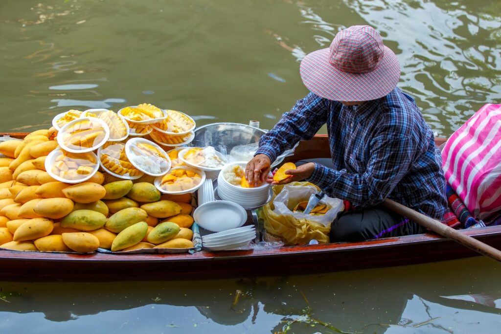 Woman selling mango sticky rice in Damnoen Saduak Floating Market