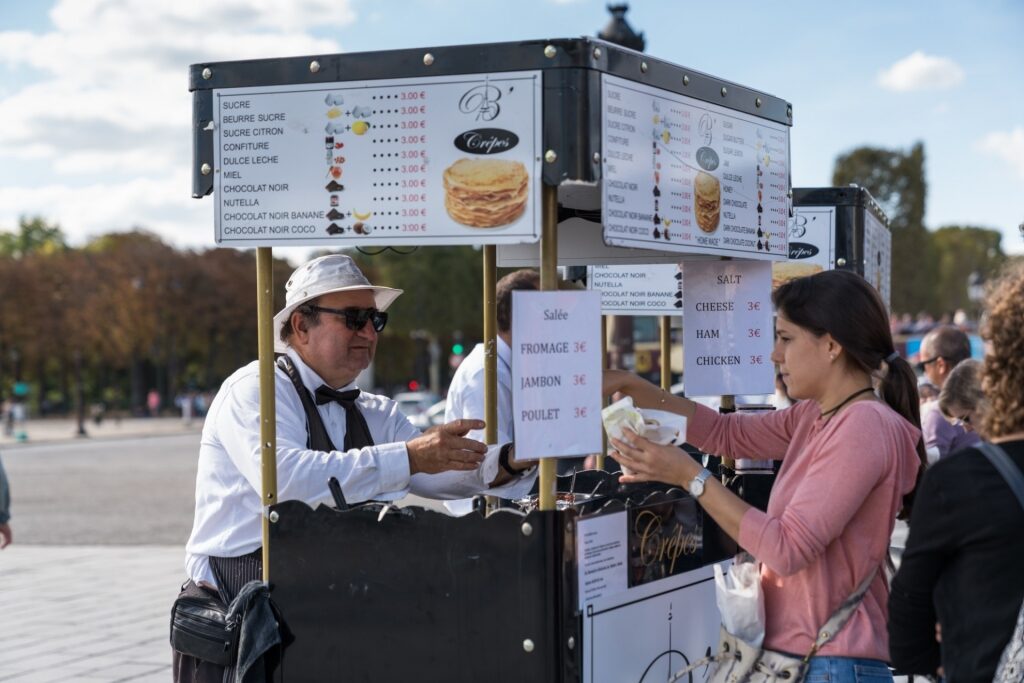 Woman buying from a crepe stall at the Place de la Concorde