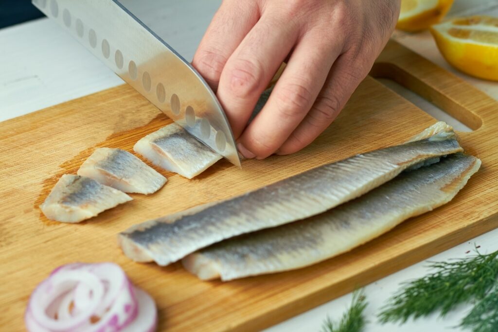 Man slicing Rauwe haring