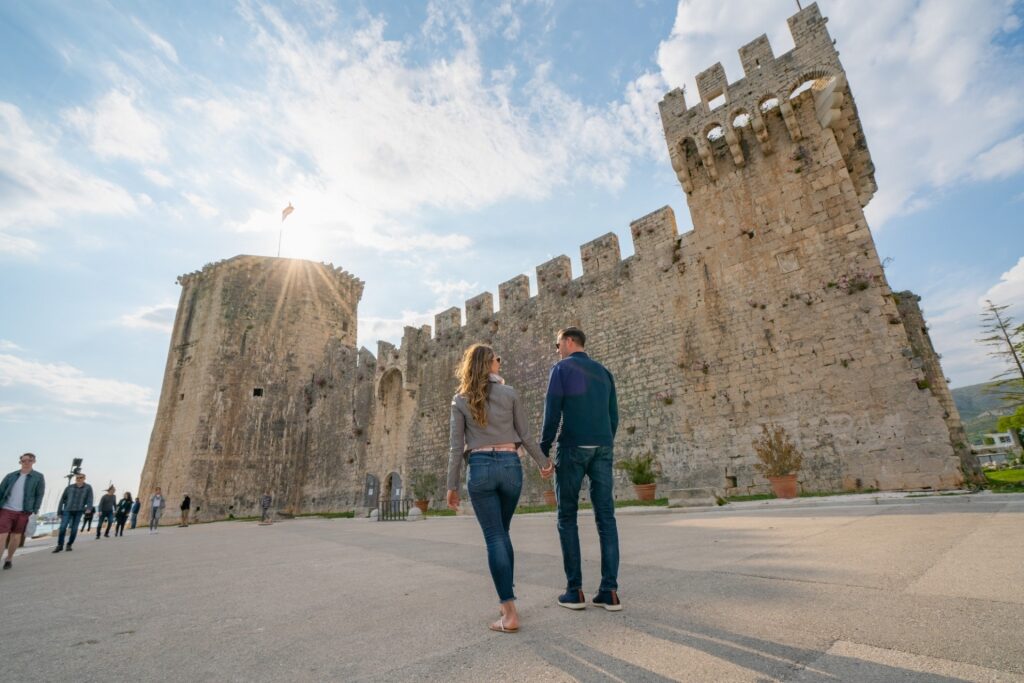 Couple walking towards Kamerlengo Castle, Trogir