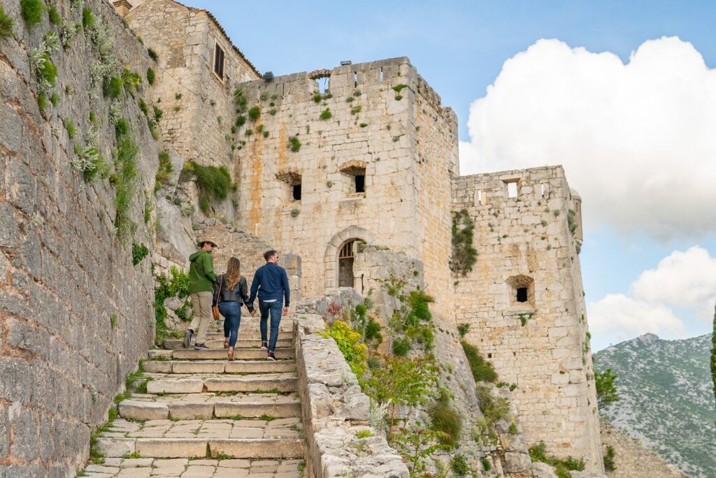 Couple climbing up Klis Fortress