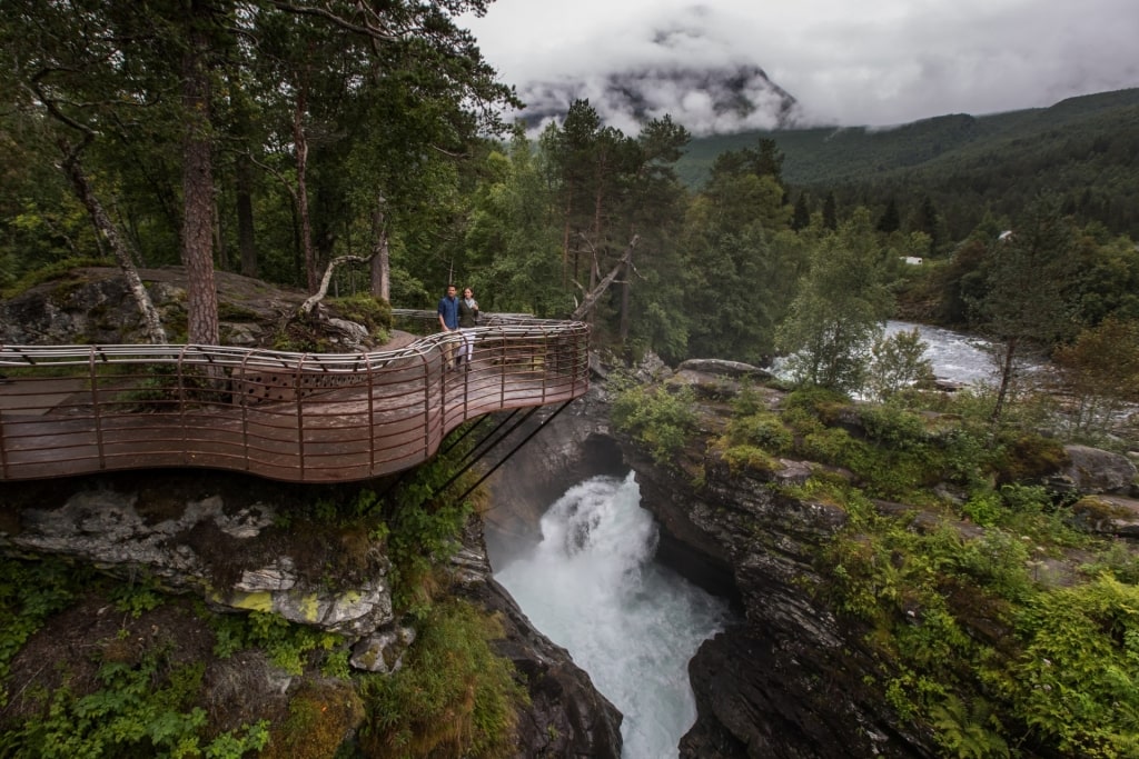 Couple sightseeing from Gudbrandsjuvet waterfall, near Alesund