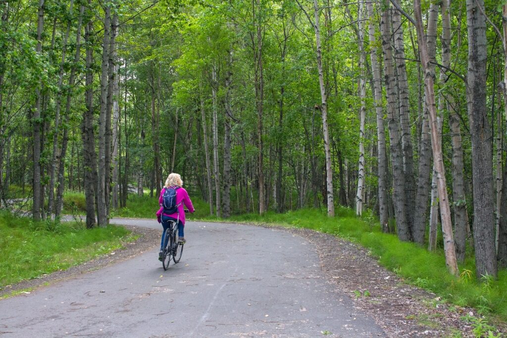 Woman biking in Tony Knowles Coastal Trail, Anchorage