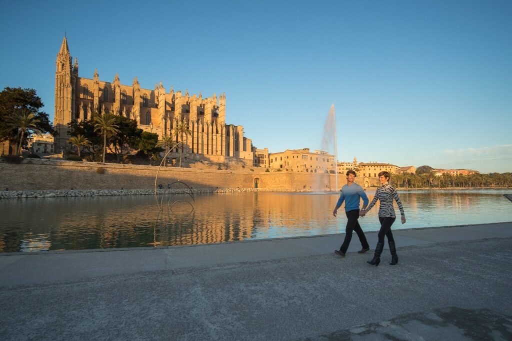 Couple walking along La Seu Cathedral