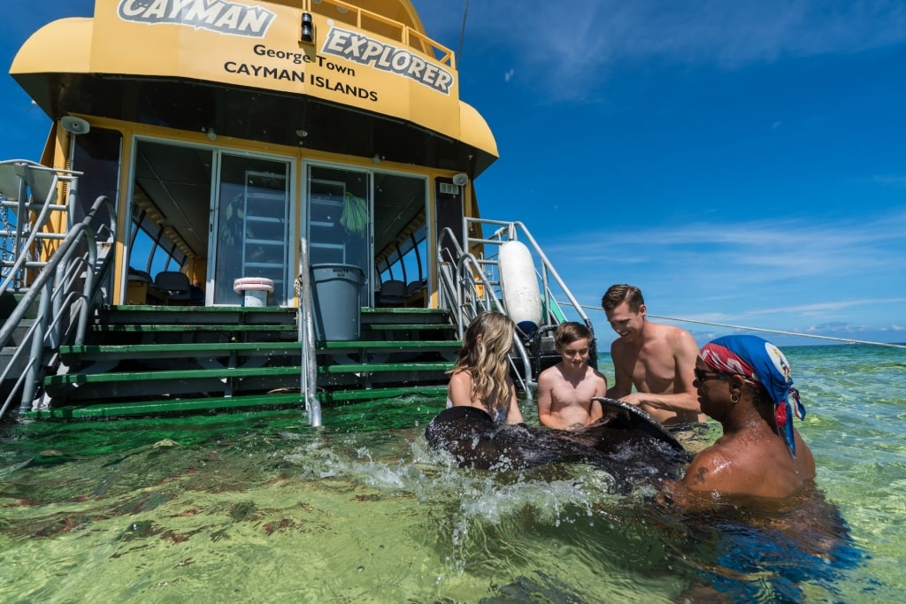 People touching a stingray at Stingray City, Grand Cayman