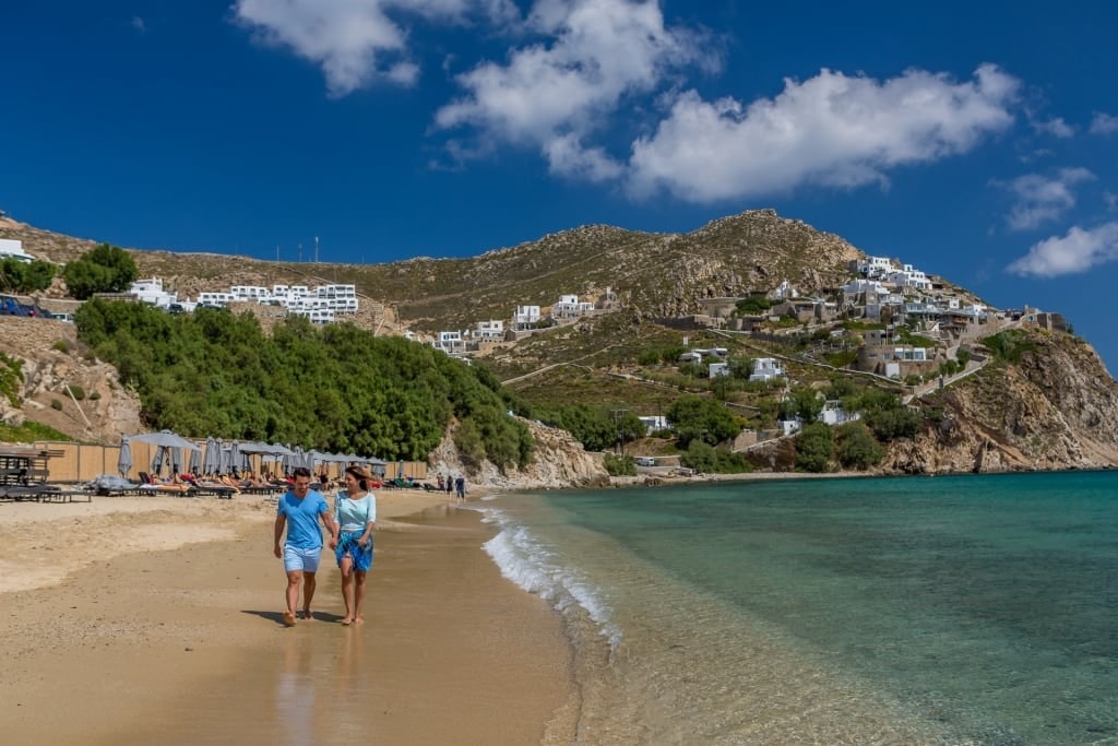 Couple strolling on a beach in Mykonos, Greece