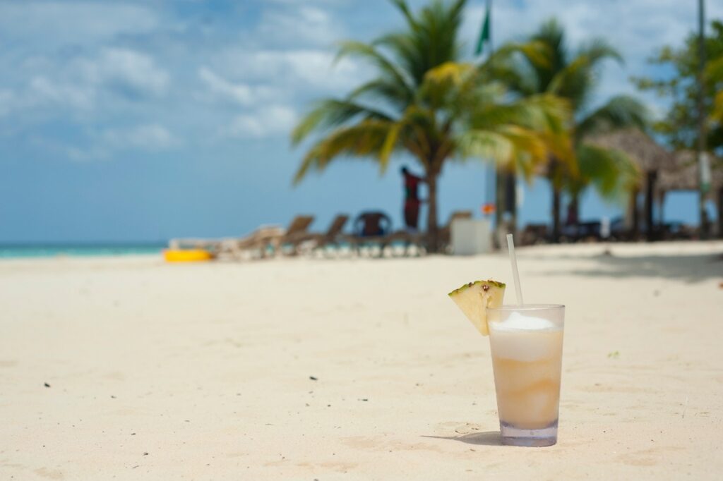 Glass of Sky Juice/Gully Wash on a beach in the Bahamas